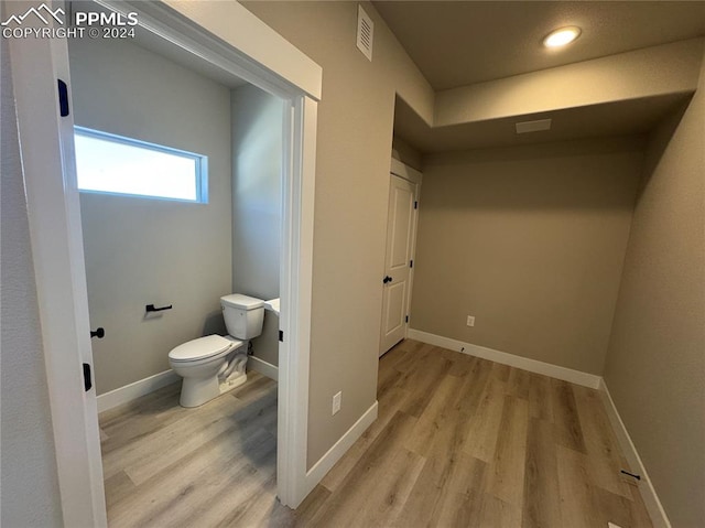 bathroom featuring hardwood / wood-style flooring and toilet