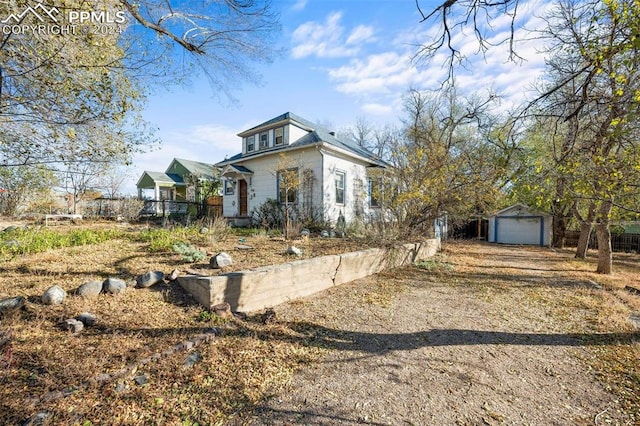 view of front facade featuring a garage and an outbuilding