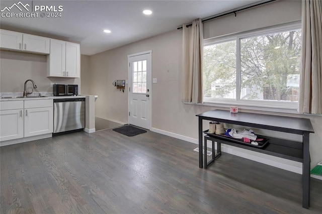 kitchen featuring dishwasher, white cabinetry, sink, and dark wood-type flooring