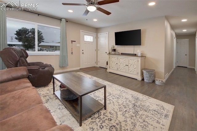 living room with dark hardwood / wood-style flooring and ceiling fan