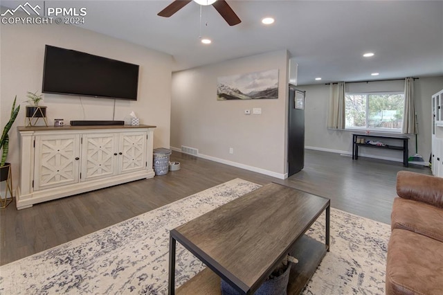 living room featuring dark hardwood / wood-style flooring and ceiling fan