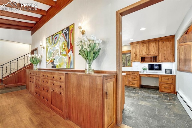 kitchen with built in desk, lofted ceiling with beams, and a baseboard heating unit