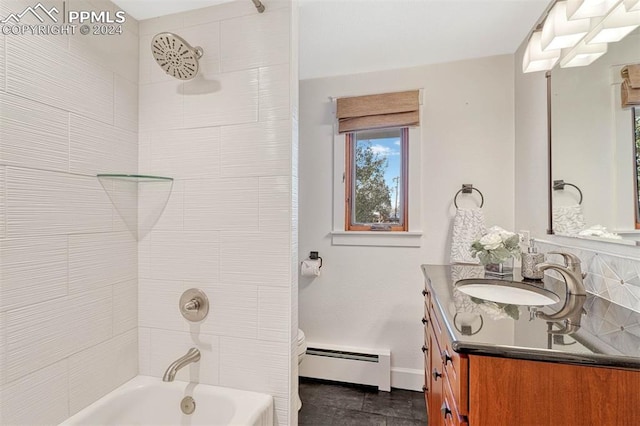 full bathroom featuring toilet, baseboard heating, tiled shower / bath, and vanity