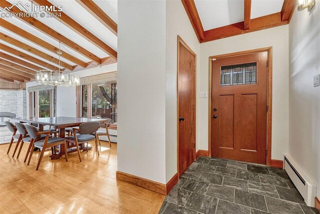 foyer entrance with a notable chandelier, lofted ceiling with beams, and a baseboard radiator