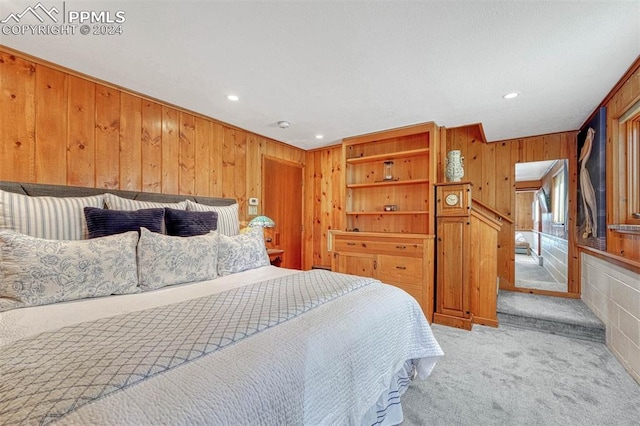 bedroom featuring light carpet, crown molding, and wooden walls