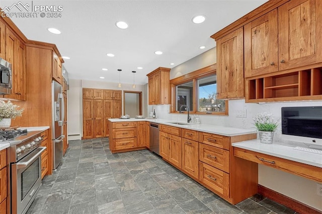 kitchen with a baseboard radiator, appliances with stainless steel finishes, sink, hanging light fixtures, and kitchen peninsula