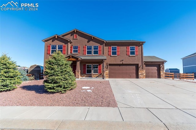 10978 Middlegate Ct, Peyton, CO 80831 - view of front facade featuring stone siding, concrete driveway, an attached garage, and stucco siding