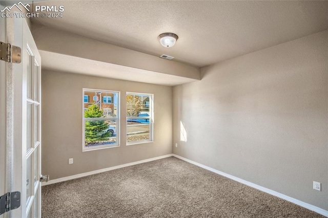 carpeted spare room with a textured ceiling