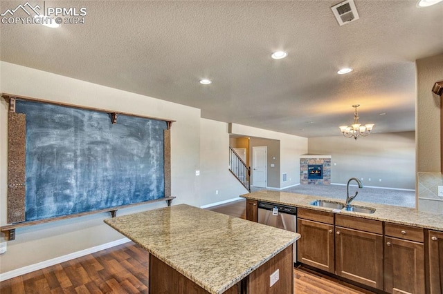 kitchen with sink, a kitchen island, decorative light fixtures, and hardwood / wood-style flooring