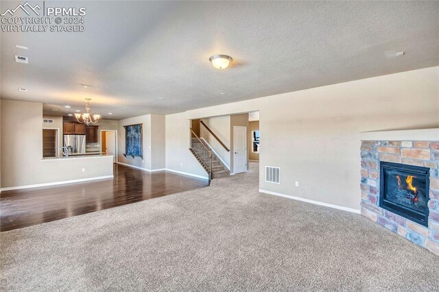 10978 Middlegate Ct, Peyton, CO 80831 - unfurnished living room with dark colored carpet, a chandelier, stairs, and baseboards