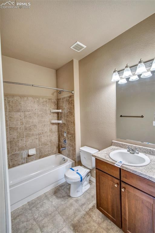 full bathroom featuring tiled shower / bath combo, toilet, a textured ceiling, and vanity