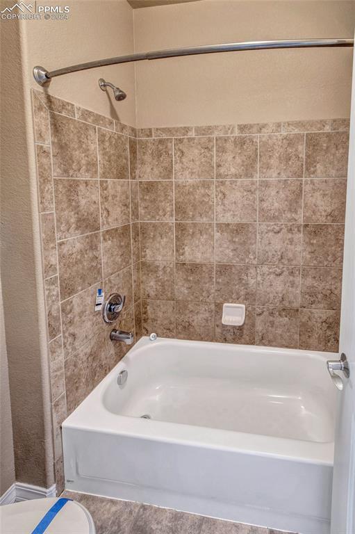 10978 Middlegate Ct, Peyton, CO 80831 - bathroom with  shower combination, tile patterned floors, and toilet