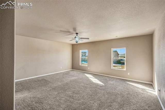 carpeted spare room with ceiling fan and a textured ceiling