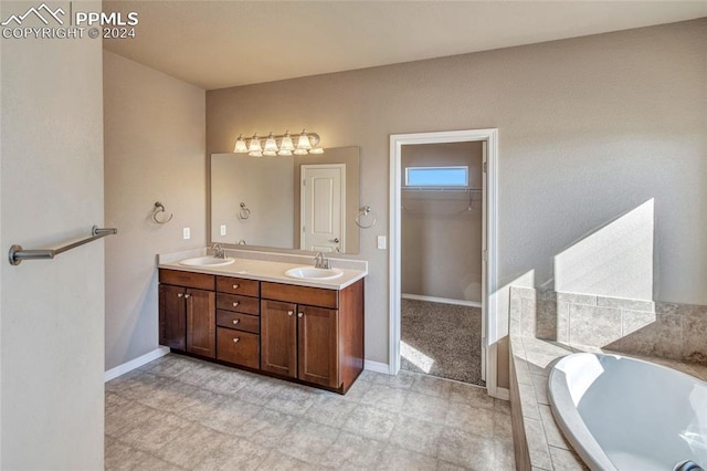 10978 Middlegate Ct, Peyton, CO 80831 - full bathroom with double vanity, a bath, a spacious closet, and baseboards