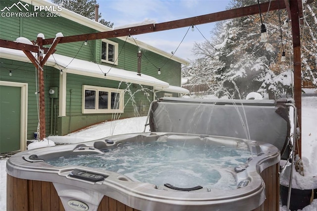 snow covered deck featuring a hot tub