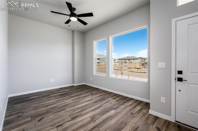 spare room featuring ceiling fan, wood-type flooring, and a wealth of natural light