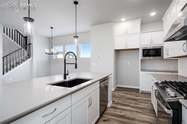 kitchen featuring sink, white cabinets, exhaust hood, and appliances with stainless steel finishes