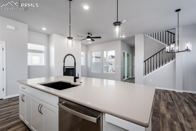 kitchen featuring dark hardwood / wood-style flooring, stainless steel dishwasher, a kitchen island with sink, sink, and white cabinetry