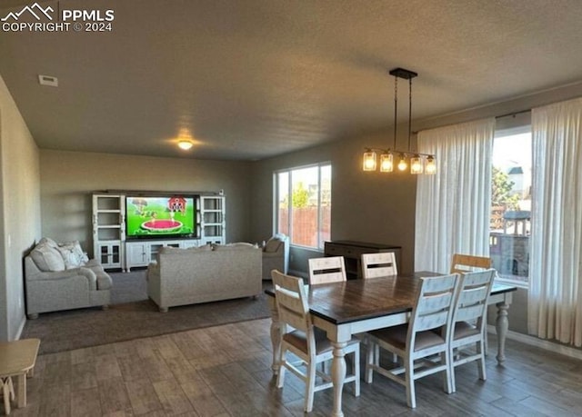 dining space with a textured ceiling and dark wood-type flooring