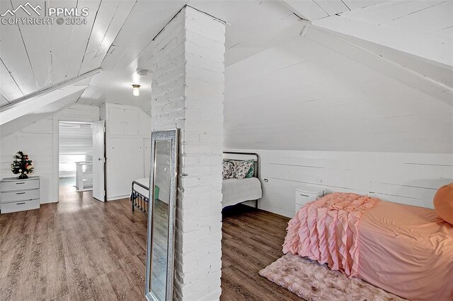 bedroom with lofted ceiling, wooden walls, wood ceiling, and wood-type flooring