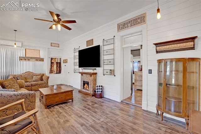 living room featuring a fireplace, wood-type flooring, wood walls, and ceiling fan