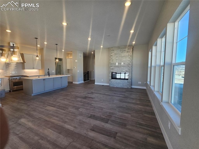 unfurnished living room featuring dark hardwood / wood-style flooring, a fireplace, and sink