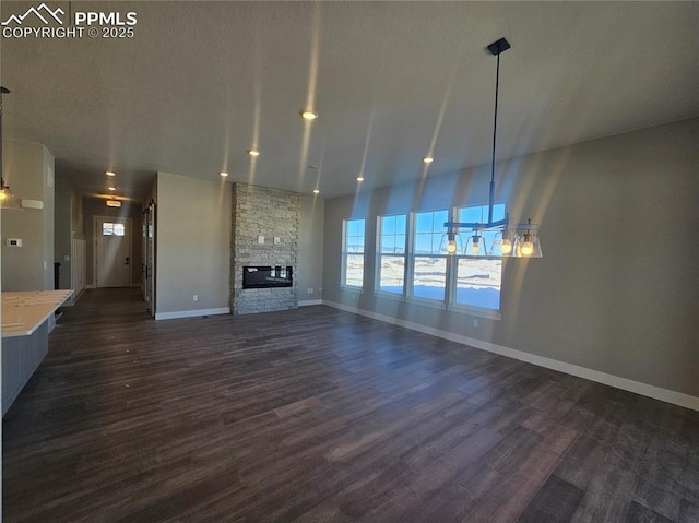 unfurnished living room featuring a fireplace and dark wood-type flooring