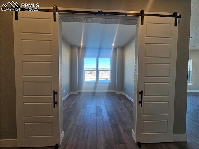 interior space with a barn door and dark wood-type flooring