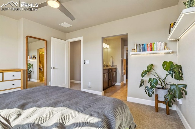 carpeted bedroom with ensuite bath and ceiling fan