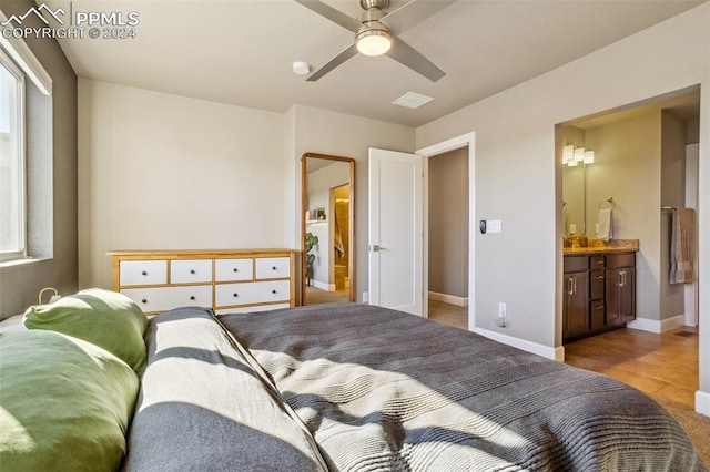 bedroom featuring light tile patterned floors, ensuite bath, and ceiling fan