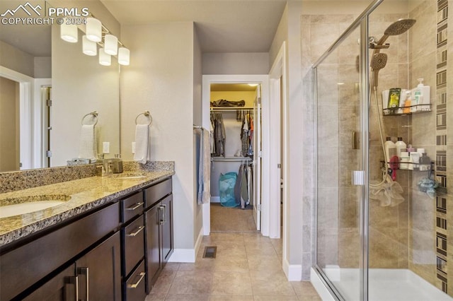 bathroom featuring tile patterned flooring, vanity, and a shower with shower door