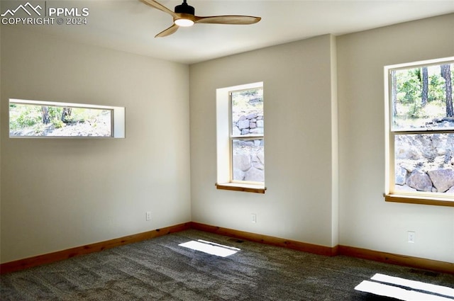 carpeted spare room featuring ceiling fan