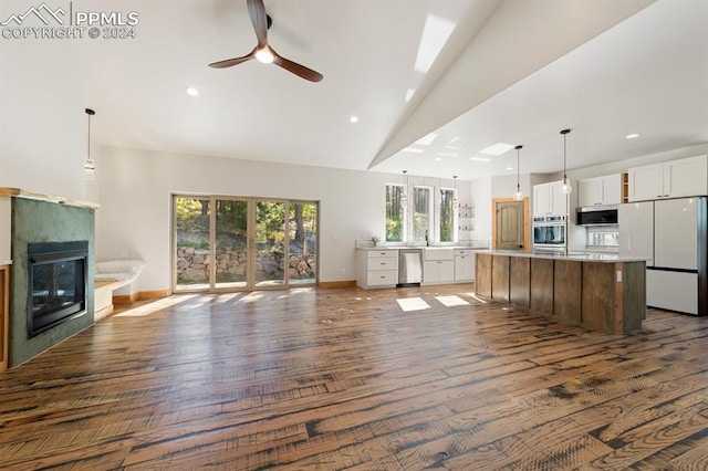 kitchen featuring white cabinets, stainless steel appliances, dark wood-type flooring, and a kitchen island