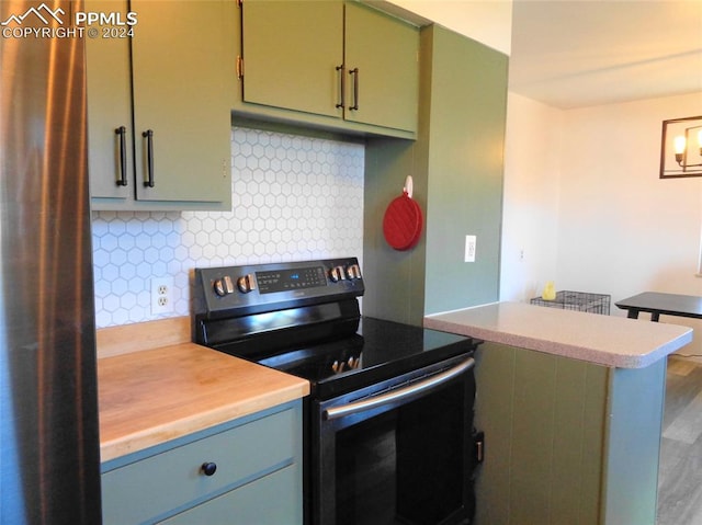 kitchen featuring hardwood / wood-style flooring, green cabinets, kitchen peninsula, backsplash, and stainless steel electric range