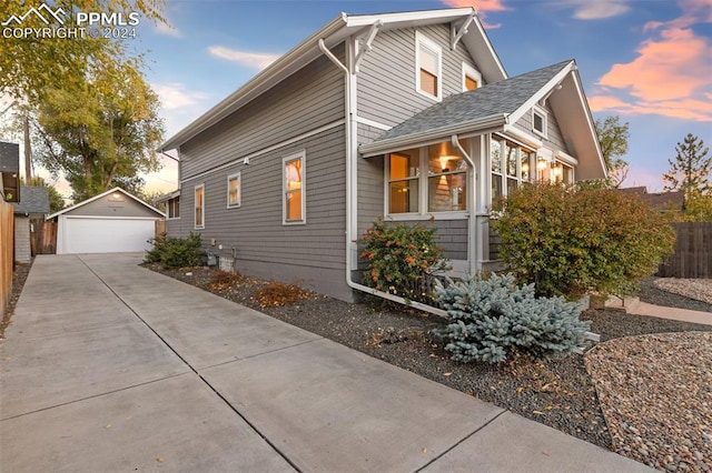 property exterior at dusk with a garage and an outdoor structure