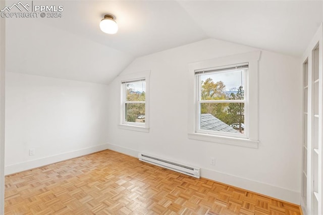 additional living space featuring light parquet floors, lofted ceiling, and a baseboard heating unit