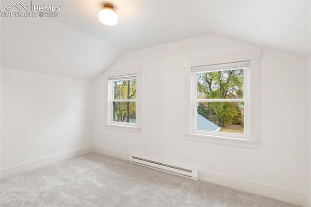 additional living space featuring lofted ceiling, light carpet, and a baseboard heating unit