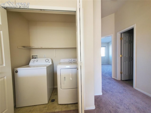 clothes washing area featuring independent washer and dryer and light carpet