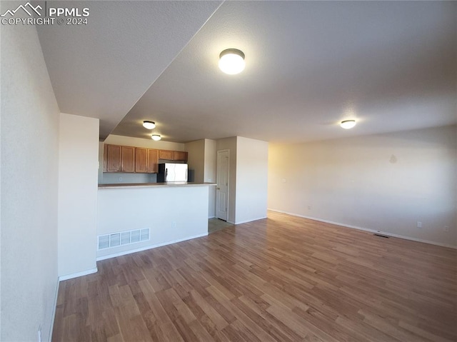 unfurnished living room featuring hardwood / wood-style flooring