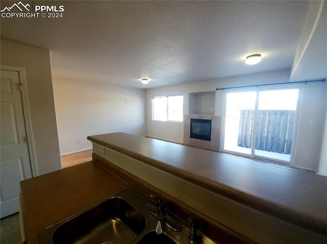 kitchen with a textured ceiling and a tiled fireplace