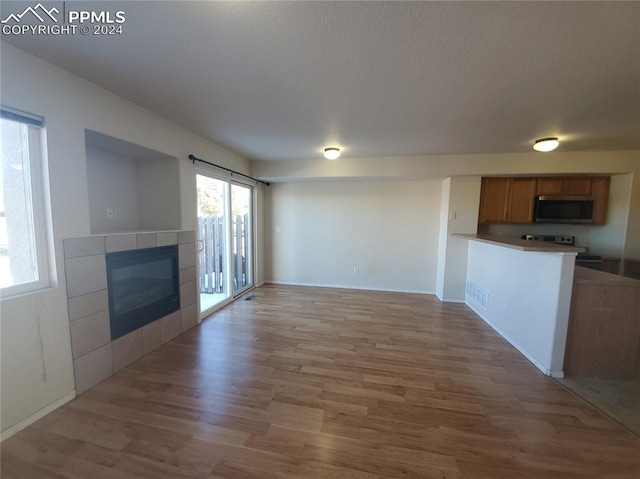 unfurnished living room with a fireplace and light wood-type flooring