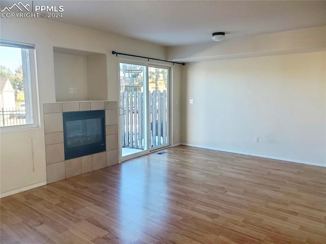 unfurnished living room with a fireplace, plenty of natural light, and light hardwood / wood-style floors