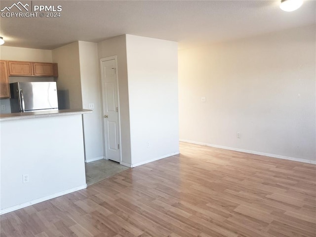 kitchen with stainless steel fridge and light wood-type flooring