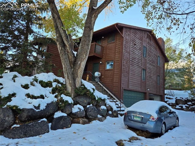 snow covered property featuring a garage