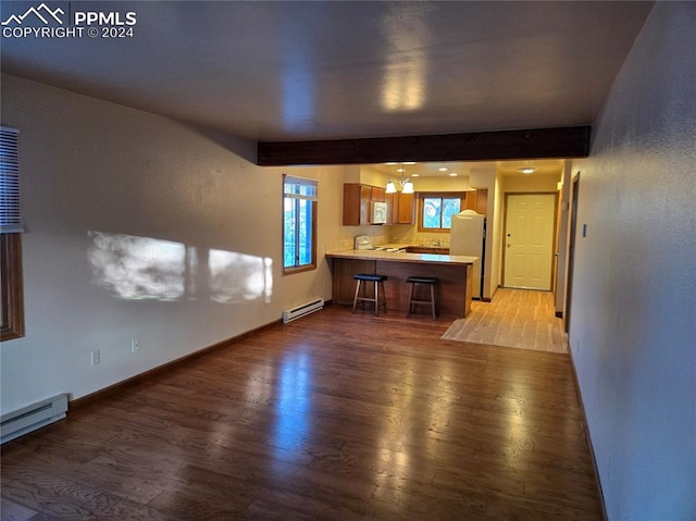 unfurnished living room featuring hardwood / wood-style floors, beamed ceiling, and a baseboard radiator