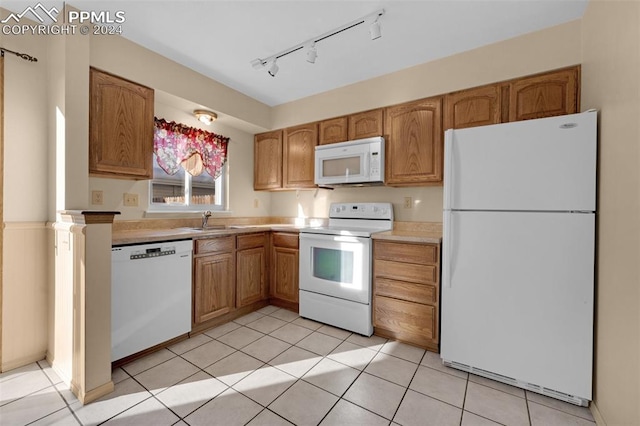 kitchen with white appliances, sink, track lighting, and light tile patterned flooring