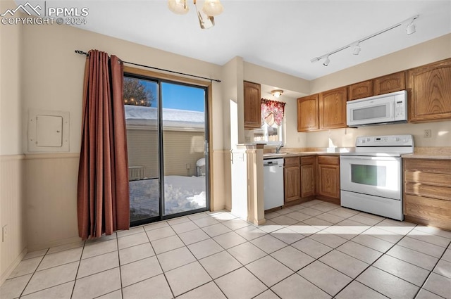 kitchen featuring electric panel, rail lighting, light tile patterned flooring, and white appliances