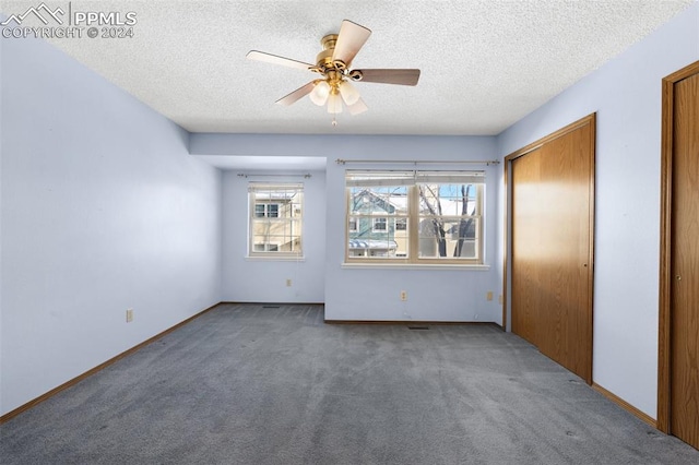 unfurnished bedroom featuring a textured ceiling, carpet floors, and ceiling fan