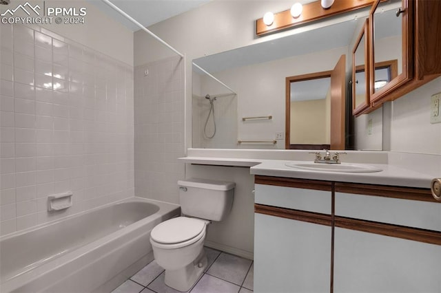 full bathroom with tile patterned flooring, vanity, tiled shower / bath combo, and toilet