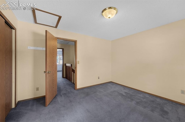 carpeted empty room featuring a textured ceiling